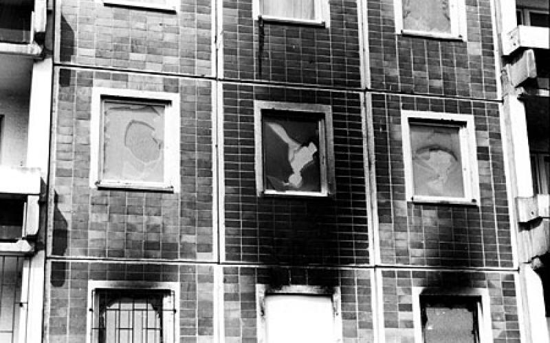 Zerstörte Fesnster und Brandspuren nach dem Pogrom in Rostock-Lichtenhagen im August 1992