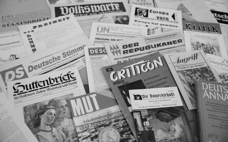 Viele Zeitschriften und Flugblätter liegen auf einem Tisch.