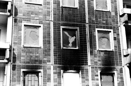 Zerstörte Fesnster und Brandspuren nach dem Pogrom in Rostock-Lichtenhagen im August 1992